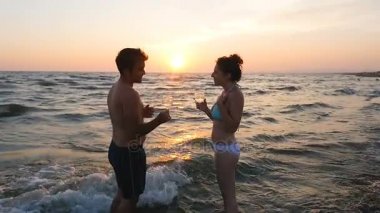 Deniz kıyısında günbatımı-sabit cam kızartma, genç Çift