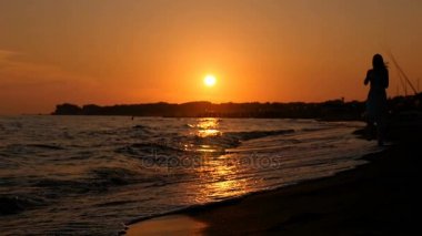 Özgürlük, gevşeme, yaz: sunset beach adlı çalışan kadın silüeti