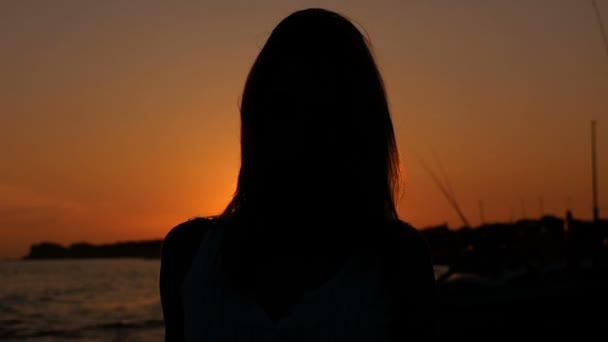 Женщина силуэт прогулки по пляжу, глядя на закат — стоковое видео