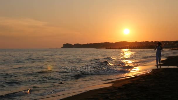 Course romantique au coucher du soleil à la plage- ralenti — Video