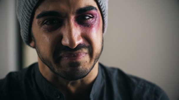 Νέος άνδρας ξυλοδαρμό και τραυματίες κραυγές κοιτάζοντας την κάμερα, εσωτερικη — Αρχείο Βίντεο