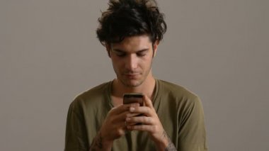 Genç yakışıklı adam typingon smartphone, gülümseyen