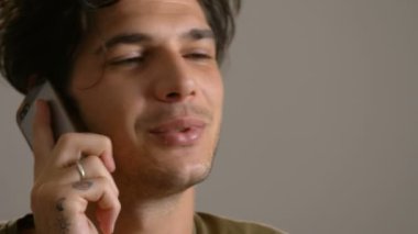 telefonla konuşan güzel genç adam gülümsüyor, yakın çekim