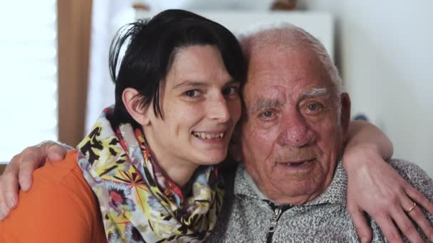 Милая внучка обкрадывает своего старого дедушку, улыбаясь в камеру. — стоковое видео