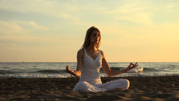 Lotuspositie (yoga) op het strand bij zonsondergang: ontspannen, meditatie, gezondheidszorg — Stockvideo