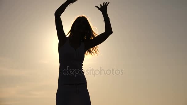 Sensual and pretty woman's silhouette dancing at sunset on the beach — Stock Video