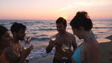 Yaz tost: 4 arkadaşlar tezahürat neşeyle gün batımında deniz kıyısı