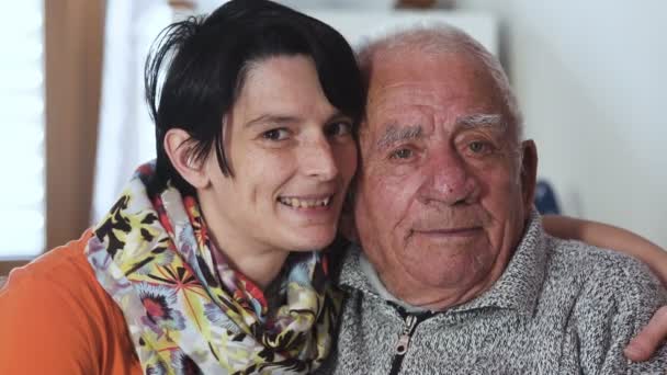Familieportret: omhelsde grootvader en grandaugther glimlachend op camera — Stockvideo