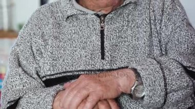 Üzgün ihtiyar kameraya bakarak onun sopa karşı yaslanmış