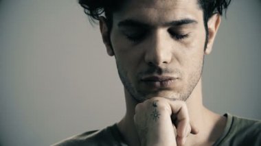 Düşünceli yakışıklı adam gözlerini açar ve kamera bakıyor