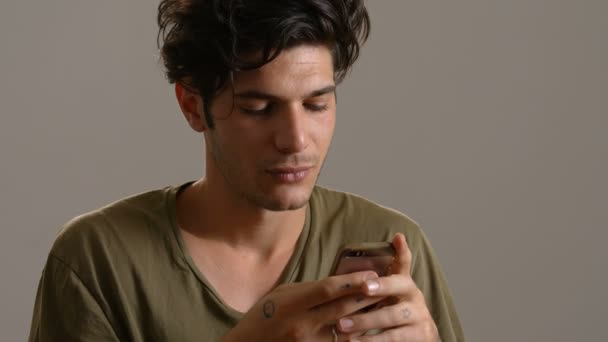 Beau jeune homme souriant et tapant sur smartphone — Video