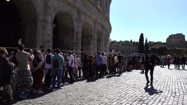 Turistien muotokuva tekevät rivin auringon alla päästäkseen Colosseumiin, Roomaan — kuvapankkivideo