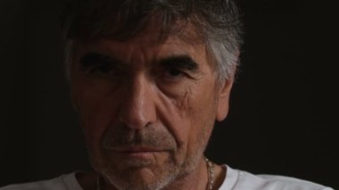 Kamera, bakan karanlıkta ciddi kızgın olgun adam yakın çekim