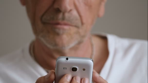 Ώριμος άνδρας πληκτρολόγηση σε smartphone — Αρχείο Βίντεο