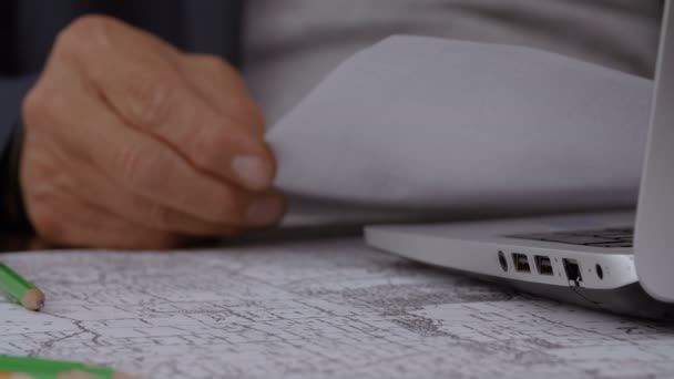 Businessman analyzes the sheets at his desk — Stock Video