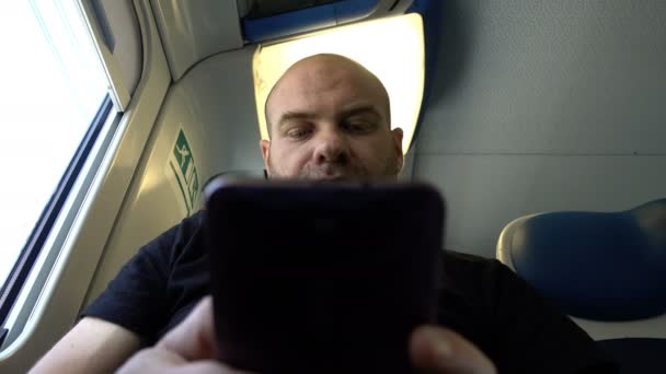 Лысый пассажир сидит в поезде — стоковое видео
