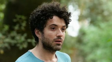 Genç, kederli, yapayalnız adam parkta