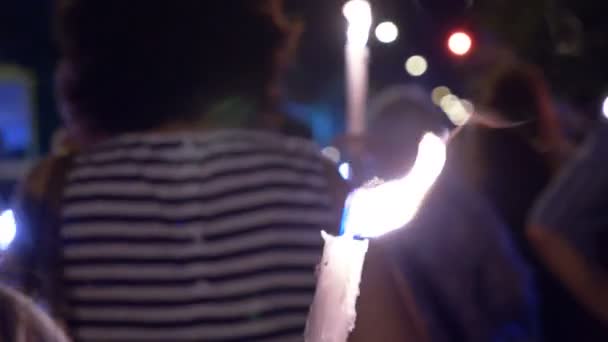 Άνθρωποι με τα πόδια σε μια πομπή που μεταφέρουν κεριά καύση — Αρχείο Βίντεο