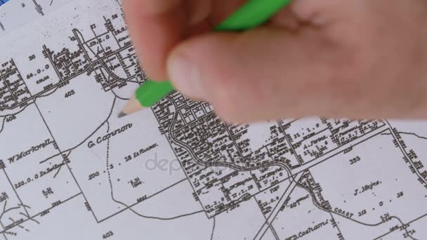 Erkek eli işaretleri yer bir harita üzerinde bir kalem ile — Stok video