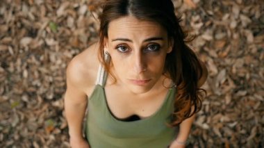 Düşünceli ve üzgün genç kadın parkta ararken