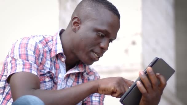 Νεαρός μαύρος άνδρας χρησιμοποιώντας το tablet — Αρχείο Βίντεο