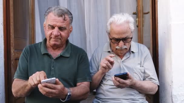 Old friends using their smartphones — Stock Video