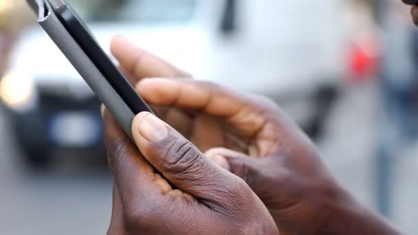 Manos del hombre negro escribiendo en el teléfono inteligente — Vídeo de stock