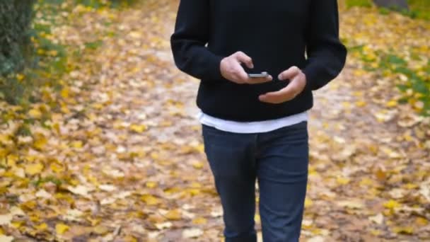 Lycklig Leende Man Promenader Och Skriva Smartphone — Stockvideo