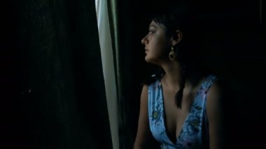  dalgın ve karanlıkta, melanchonic kadın pencereden dışarı bakarak