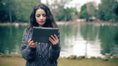 Güzel esmer dijital tablet kaydırma ve gülümseyen-açık