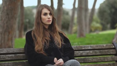 Bir bankta oturan dalgın ve üzgün kadın portresi