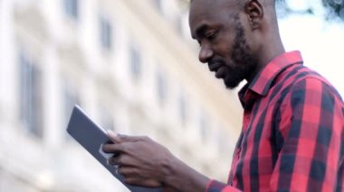 Genç balck adam sokakta dijital tablet kullanma