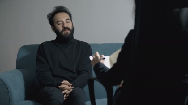 mladý muž mluví s psychologem, sedí psychoterapeut
