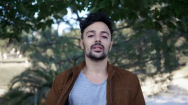 parkta genç çekici adam kameraya benziyor: huzur, kanaat