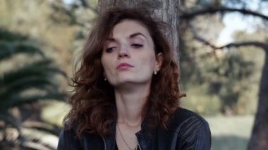 bir ağacın altında oturan bir depresif ve düşünceli Bayan