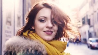 gülümseyen güzel genç kadın kafasını çevirerek sokakta ve gülümseyen