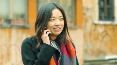  Çinli kadın sokakta telefonla konuşurken rahat