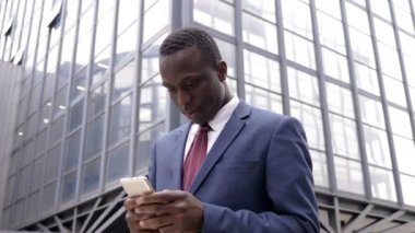 yakışıklı Afrika siyah sokakta genç adam tyoing onun smartphone-açık
