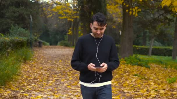 Sonriente Relajado Joven Caminando Por Parque Escuchando Música — Vídeos de Stock