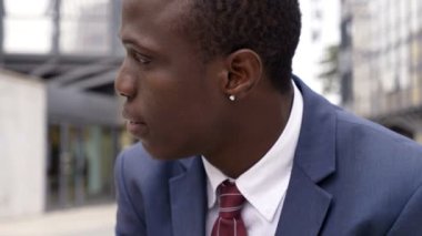 Kendine güvenen genç siyah businness seyir ve kameraya gülümseyen adam