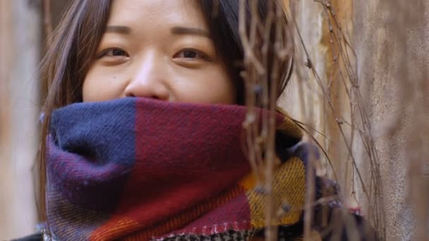 Divertida Joven Mujer China Sonrisas Ocultas Bufanda Aire Libre — Vídeo de stock