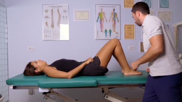 Физиотерапевт массирует спину пациента под давлением — стоковое видео