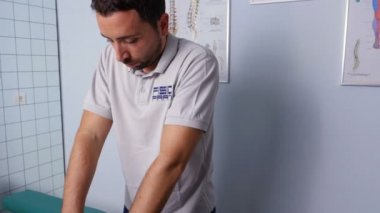 fizyoterapist basınçla bir hasta arkası masajlar.