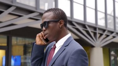 Sokakta telefonla konuşurken sevimli yakışıklı siyah iş adamı