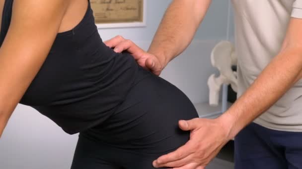Masajes fisioterapeutas con presión en la espalda de un paciente — Vídeo de stock