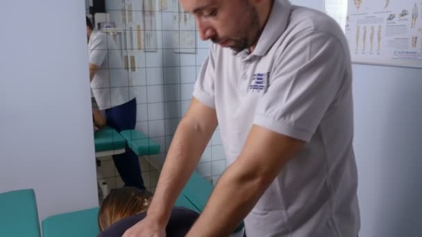 Fisioterapista massaggia con pressione la schiena di un paziente — Video Stock