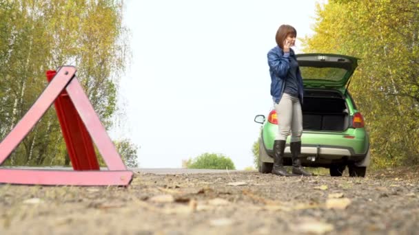 Žena, že nouzové volání služby zotavení s rozbité auto. Výstražný trojúhelník na venkovské silnici — Stock video