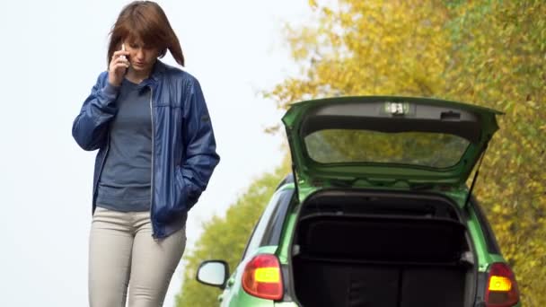 La mujer que hace una llamada de emergencia a los servicios de recuperación con el coche roto. Triángulo de advertencia en la carretera del país — Vídeos de Stock