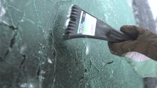 Jovem mulher limpando neve e gelo de seu carro. Inverno tempestade de neve — Vídeo de Stock