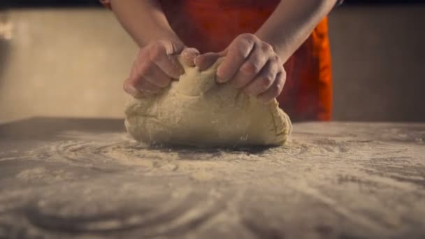 Vrouwelijke handen kneden van de deeg in meel op tafel. Slow motion — Stockvideo